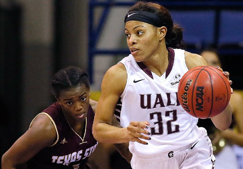 UALR guard Ka’Nesheia Cobbins (32) dribbles past Texas State guard Ayriel Anderson during the second half of the Trojans’ 87-44 victory Friday in the semifinals of the Sun Belt Tournament in New Orleans.