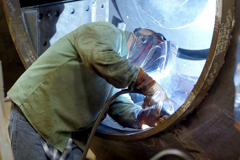 A welder works last month on part of a fan for an industrial ventilation system at the Robinson Fans Inc. plant in Harmony, Pa. As wholesale prices fell in February, energy costs overall were flat, the Labor Department said Friday. 