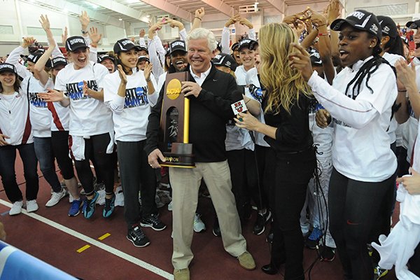 Arkansas coach Lance Harter (center) is presented with the National Championship trophy Saturday, March 14, 2015, after the Arkansas women's team won the NCAA Indoor Track and Field Championship at the Randal Tyson Track Center in Fayetteville.