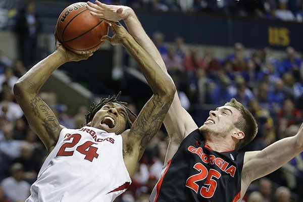 Arkansas guard Michael Qualls (24) shoots against Georgia forward Kenny Paul Geno (25) during the first half of an NCAA college basketball game in the semifinal round of the Southeastern Conference tournament, Saturday, March 14, 2015, in Nashville, Tenn. (AP Photo/Mark Humphrey)