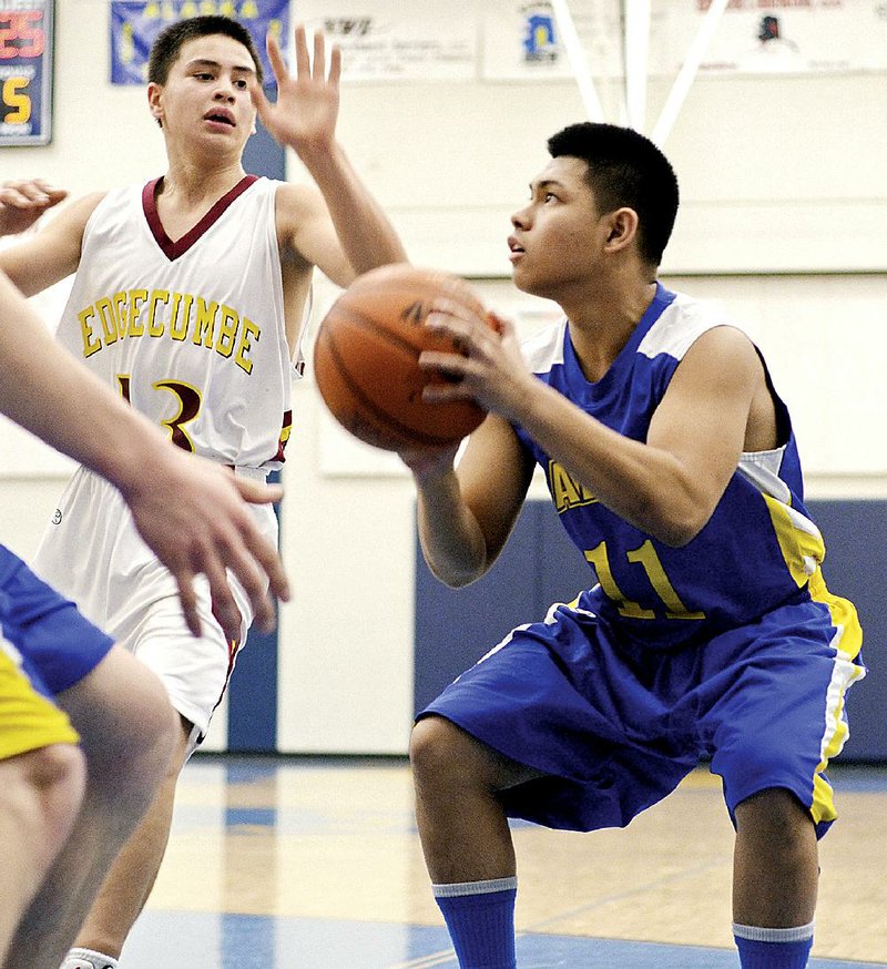 ADVANCE FOR USE SATURDAY, MARCH 14, 2015 AND THEREAFTER - In this Jan. 8, 2015, photo, Kodiak High School's Chris Caguing looks to shoot during a high school basketball game against Mt. Edgecumbe in Kodiak, Alaska. Earlier this year Chris suited up with his two brothers to play for the varsity team. (AP Photo/Kodiak Daily Mirror, Derek Clarkston)