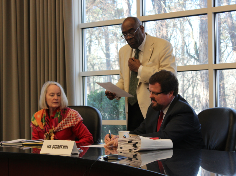 Commissioner Stuart Hill signs a resolution after the Independent Citizens Commission passed its final report on salary changes for elected officials Monday, March 16, 2015. Commission Chairman Larry Ross and Commissioner Barbara Graves are to his right.