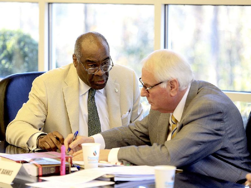 Arkansas Democrat-Gazette/STATON BREIDENTHAL --3/16/15-- Chairman Larry Ross (left) and Vice Chairman Chuck Banks  sign the salary recommendations of the Independent Citizens Commission Monday during their meeting in Little Rock.  The commission voted 5-2 to adopt its review of salaries for Arkansas' legislators, constitutional officers and judges.