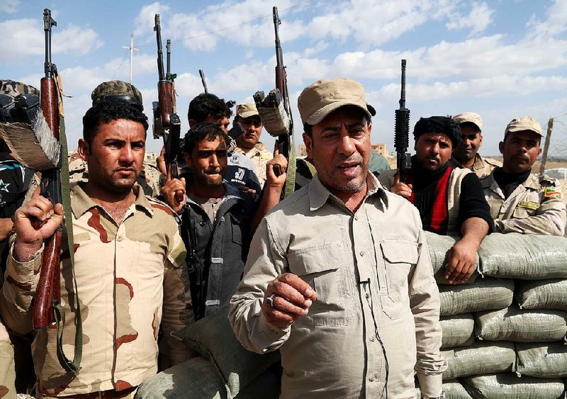 Hakim al-Zamili, a parliament member and head of Security and Defense Committee, right, visits the front line during a battle against Islamic State militants in Tikrit, 130 kilometers (80 miles) north of Baghdad, Iraq, Monday, March 16, 2015. The offensive to retake Saddam Hussein’s hometown of Tikrit began March 2. The city is one of the largest held by the Islamic State militants on the road connected Baghdad and Mosul. Iraqi Interior Minister Mohammed Salem al-Ghabban said Monday that the campaign had halted temporarily to allow civilians in the city to evacuate and to enable troops to clear roadside bombs planted by the extremists. (AP Photo/Khalid Mohammed)