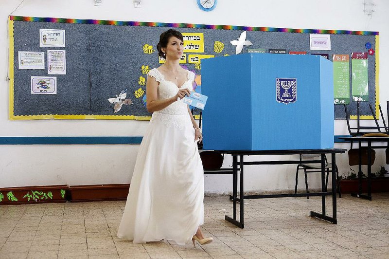 A new bride casts her vote Tuesday in Israel’s parliamentary elections in Holon near Tel Aviv.