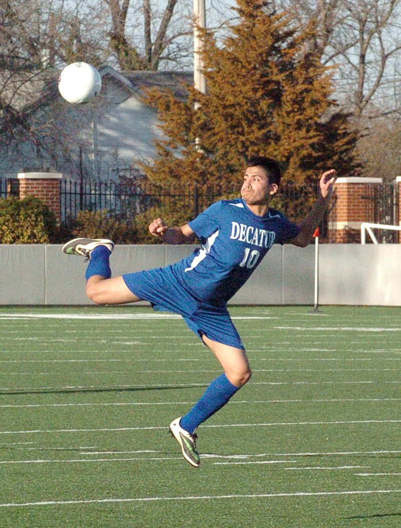 Photo by Mike Eckels Tony Mendoza (Decatur #10) performs a reverse kick in an effort to pass the ball to one of his teammates during the Springdale Bulldogs &#8211; Decatur Bulldogs matchup at Bulldog Stadium in Springdale March 11. Springdale took the game 4 to 3.