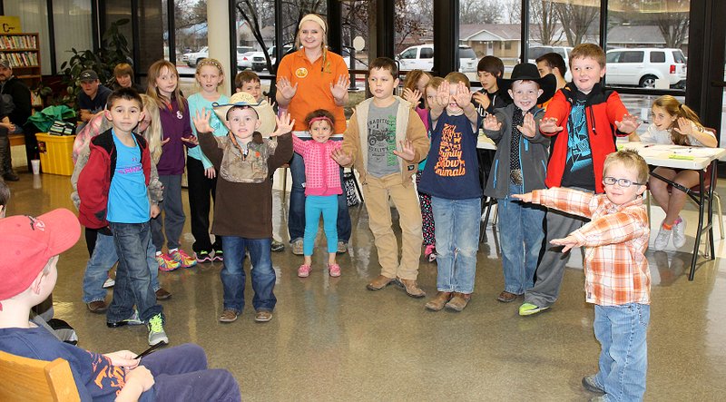 Submitted Photo Members of the Gentry Outdoor Adventures 4-H Coverbuds, with instructor Lydia Macfarlan, illustrate what to do should they come across a gun: &#8220;Stop! Don&#8217;t Touch. Leave the Area. Tell an Adult.&#8221;