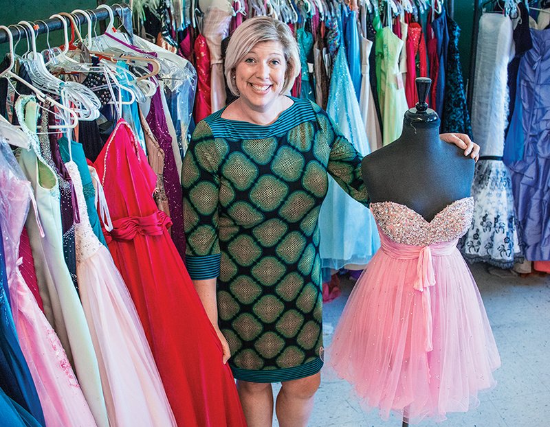 Leigh Keller, a counselor at Batesville High School, stands by some of the donated dresses she has gathered to help make sure students who want a dress for the prom can get one.
