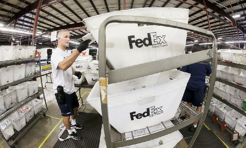 A FedEx employee sorts packages at the FedEx Express station in Nashville, Tenn., last year. FedEx said Wednesday it earned $580 million, or $2.01 per share, in the three months ended Feb. 28. 