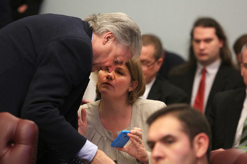 Rep. Mark Lowery confers with Karen Lamoreaux of Arkansas Against Common Core during a Senate Education Committee meeting on his bill to end a new school assessment exam. 