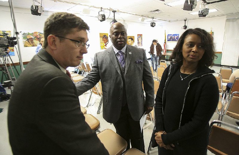 Little Rock School District Interim Superintendent Dexter Suggs (middle) talks with former school board members Jim Ross (left) and Joy Springer (right) following a press conference at district headquarters one day after the state voted to take control of the district in this file photo. 