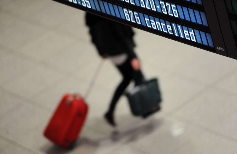 A woman passes by a panel with the writing 'cancelled' on it Wednesday, March 18, 2015 at the airport in Munich, southern Germany. Hundreds of flights have been canceled in a strike by Lufthansa pilots at the German airline's short- and medium-haul operations  the latest in a string of walkouts.