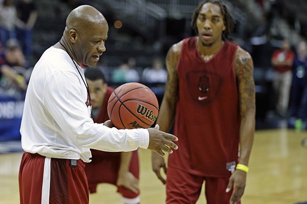 Arkansas head coach Mike Anderson (left) talks with players, including guard Michael Qualls, during practice for an NCAA college basketball second-round game in Jacksonville, Fla., in this March 18 file photo.