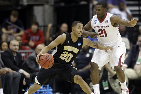 Wofford guard Jaylen Allen (20) drives against Arkansas guard Manuale Watkins (21) during the first half of an NCAA tournament second round college basketball game Thursday, March 19, 2015, in Jacksonville, Fla. (AP Photo/John Raoux)