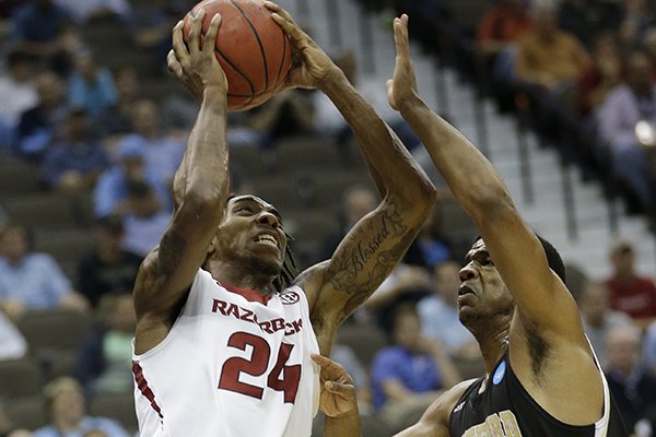 Arkansas guard Michael Qualls (24) shoots against Wofford guard Spencer Collins (14) during the first half of an NCAA tournament second round college basketball game Thursday, March 19, 2015, in Jacksonville, Fla. (AP Photo/John Raoux)