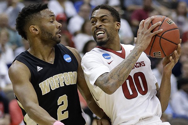 Arkansas guard Rashad Madden (00) drives into Wofford guard Karl Cochran (2) during the first half of an NCAA tournament second round college basketball game Thursday, March 19, 2015, in Jacksonville, Fla. (AP Photo/John Raoux)
