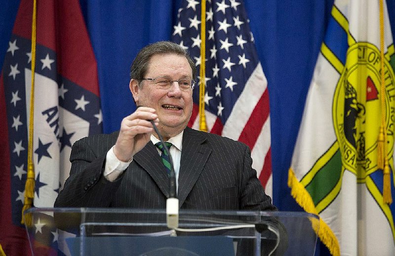 Little Rock Mayor Mark Stodola adjusts his microphone before speaking to a crowd for his 2015 State of the City address held at the 12th Street Station on Thursday. The mayor announced a program between the city and AmeriCorps for free home renovations and repairs to low-income families starting later this year. 