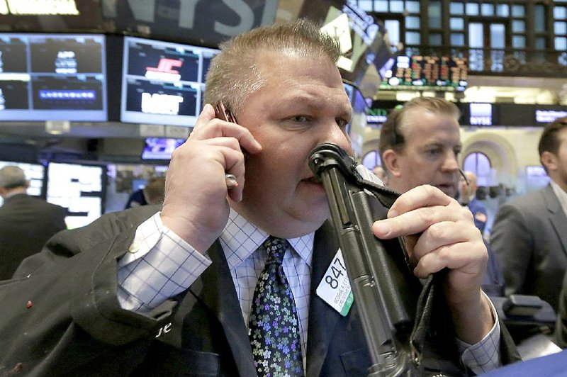 Trader George Ettinger (center) works on the floor of the New York Stock Exchange, where stocks slumped Thursday after a rally the day before. 