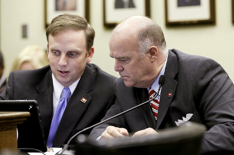 Rep. Matthew Shepherd (left) confers with Rep. Joe Jett in the House Revenue and Taxation Committee meeting Thursday during discussion on Shepherd’s amended bill restoring capital-gains tax cuts. 