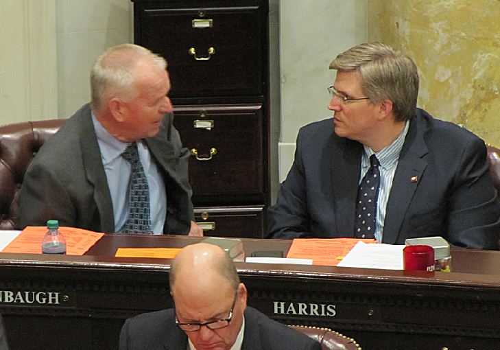 Rep. Justin Harris, R-West Fork, right, talks with Rep. Gary Deffenbaugh, R-Van Buren, before the House voted on a bill to ban re-homing adoptive children Friday.