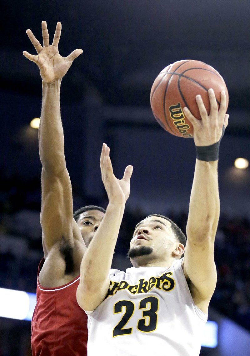 Wichita State guard Fred VanVleet (23) drives to the basket past Indiana guard Robert Johnson during the second half of an NCAA tournament college basketball game in the Round of 64, Friday, March 20, 2015, in Omaha, Neb. VanVleet scored 27 points as Wichita State won 81-76. (AP Photo/Charlie Neibergall)