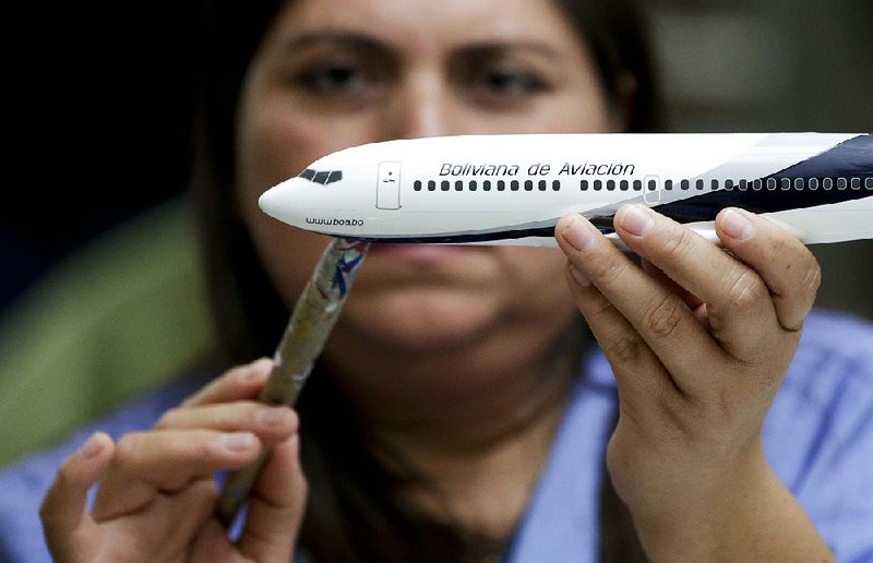 In this Feb. 5, 2015 photo, Diocelina Barajas applies decals to a model plane at Pacific Miniatures in Fullerton, Calif. When airlines open new routes, make deals with other carriers or finance new jets, there is a gifting of high-quality models. They are used to break the ice at difficult meetings, are tremendous marketing tools and a favored way of saying thank you. (AP Photo/Chris Carlson)