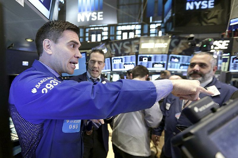 Specialist Robert Tuccillo, left, works traders on the floor of the New York Stock Exchange, Friday, March 20, 2015. Stocks are moving higher in early trading as investors respond to some surprisingly strong earnings from U.S. companies. (AP Photo/Richard Drew)