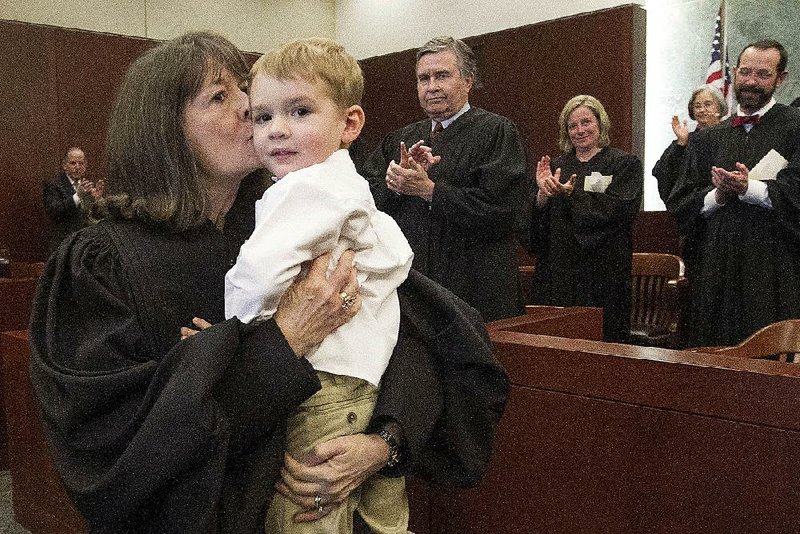Arkansas Democrat-Gazette/BENJAMIN KRAIN --3/20/15--
Phyllis Jones and her grandson Tucker Moore are applauded by Federal Judges after being robed as a new United States Bankruptcy Judge during an investiture ceremony at the Federal Courthouse in Little Rock on Friday.