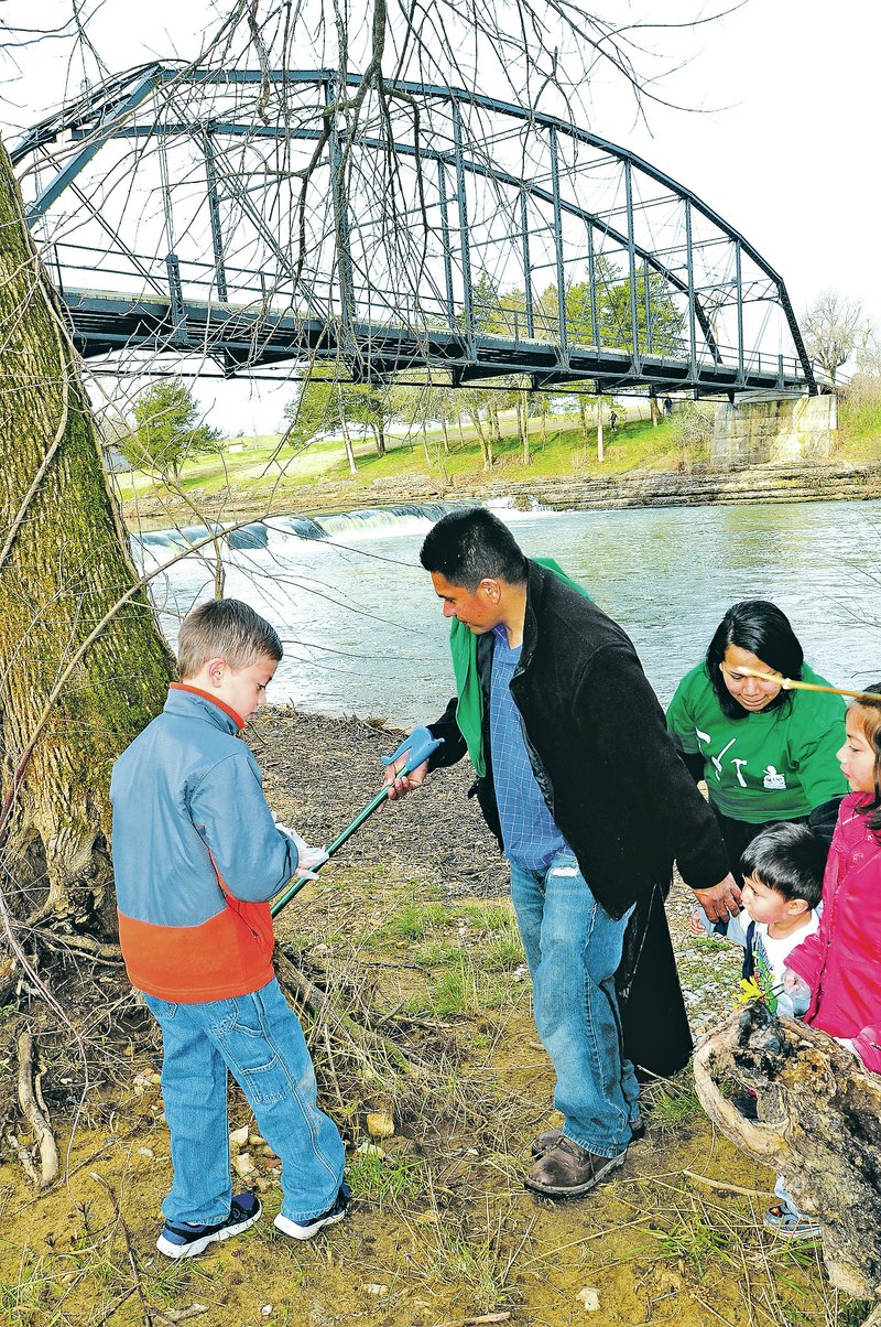 NWA Democrat-Gazette/FLIP PUTTHOFF Isaac Amaya, 8, (left) and his dad, Miguel Amaya of Springdale take part in the War Eagle Cleanup Saturday with Ana Rivera and Iris Amaya, 6 (right). They picked up litter near the historic War Eagle bridge. For photo galleries, go to nwadg.com/photos.