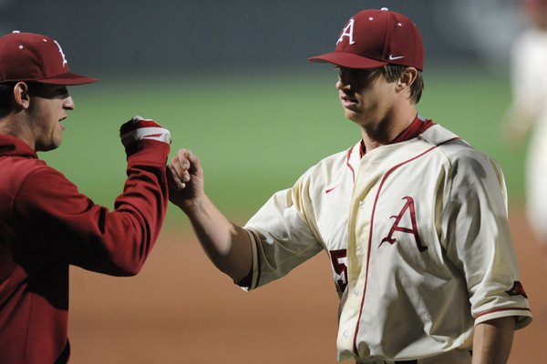 Starter Dominic Taccolini of Arkansas is congratulated after the final out of the sixth inning against LSU Thursday, March 19, 2015, at Baum Stadium in Fayetteville.