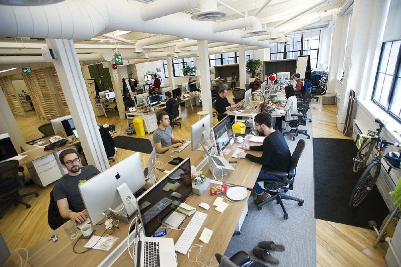 Employees at Shopify Inc. work in their office space in Toronto, Ontario, Canada, on March 13, 2015. Rents for brick-and-beam real estate in the city's east end rose 26 percent to C$20.62 ($16.13) a square foot from 2007 and were up 49 percent in the west end, according to data compiled by CBRE Group Inc. Photographer: Kevin Van Paassen/Bloomberg