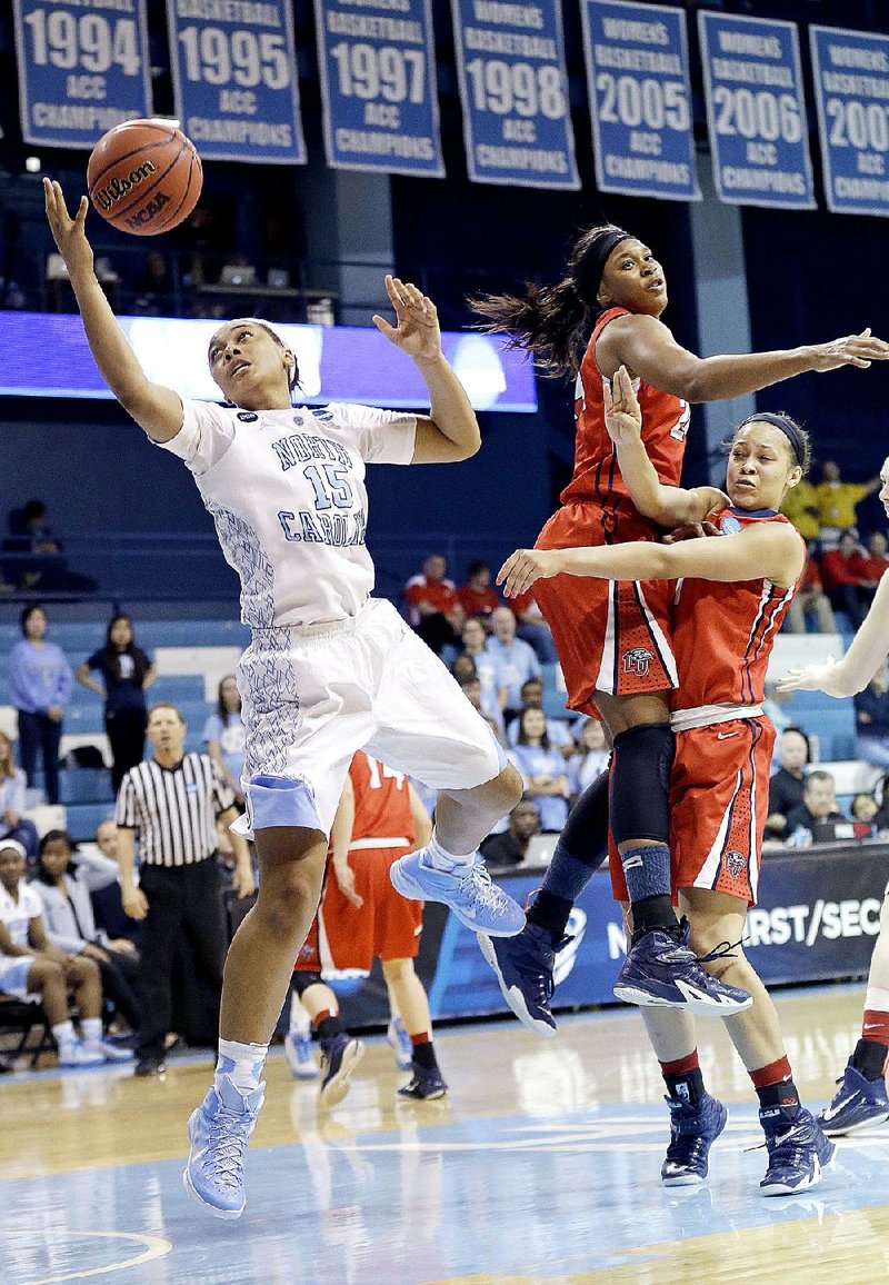 North Carolina's Allisha Gray (15) drives to the basket past Liberty's Jasmine Gardner and Mickayla Sanders, right, during the second half of a women's college basketball game in the first round of the NCAA tournament in Chapel Hill, N.C., Saturday, March 21, 2015. North Carolina won 71-65. (AP Photo/Gerry Broome)