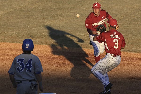Arkansas short stop Brett McAfee (middle) flips the ball to second baseman Michael Bernal (right) to force out Memphis runner Kane Barrow Tuesday, March 24, 2015, at Dickey-Stephens Park in North Little Rock.