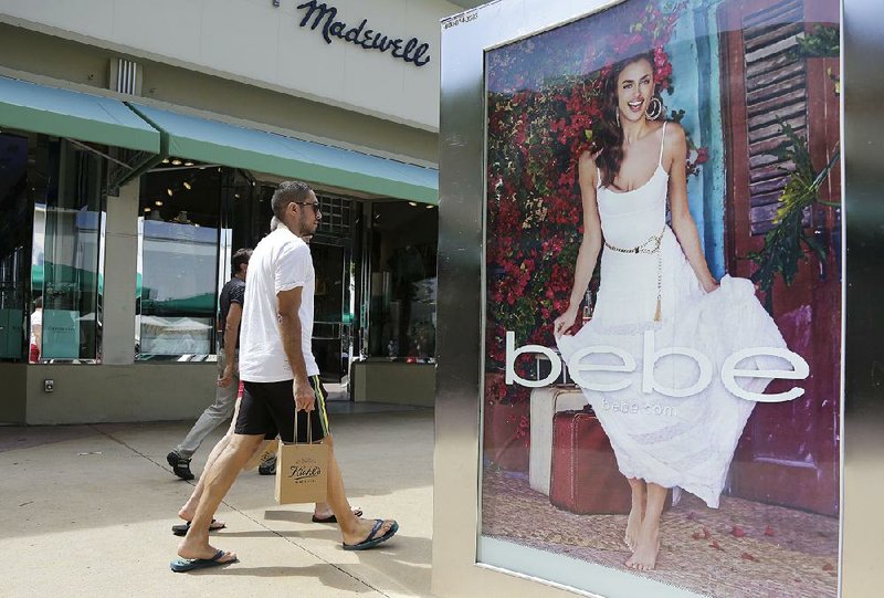 Shoppers pass an advertisement for retailer Bebe at Lincoln Road Mall, a pedestrian mall featuring stores and outdoor cafes in Miami Beach, Fla. A jump in gasoline prices helped push the consumer price index up in February.