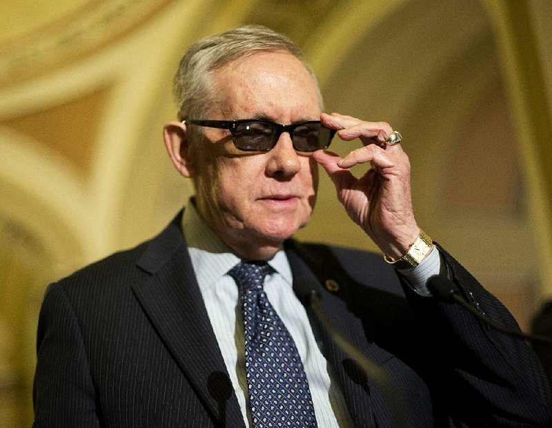 Senate Minority Leader Harry Reid adjusts his glasses as he speaks to reporters Tuesday on Capitol Hill in Washington. Reid is wearing special glasses as part of his recovery from injuries suffered in an exercise accident in January.