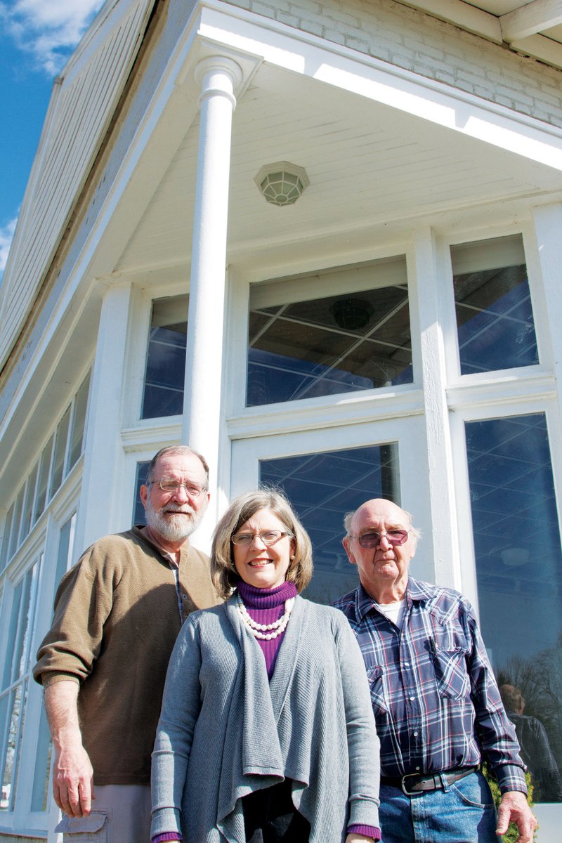 From left, Tom Riley, Judy Riley and Roydale Breckenridge stand in front of the building that will soon house a library in El Paso. The project to turn the old bank building into a library has been going on for years, and the volunteers who have been working on the project are hopeful it will be completed in a few months.