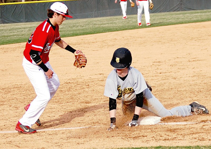 BEN MADRID ENTERPRISE-LEADER Prairie Grove&#8217;s Isaac Disney slides in front of Farmington&#8217;s Drew Vinson. The Tigers defeated the Cardinals, 11-4, on March 16 in a non-conference baseball contest hosted by Farmington.