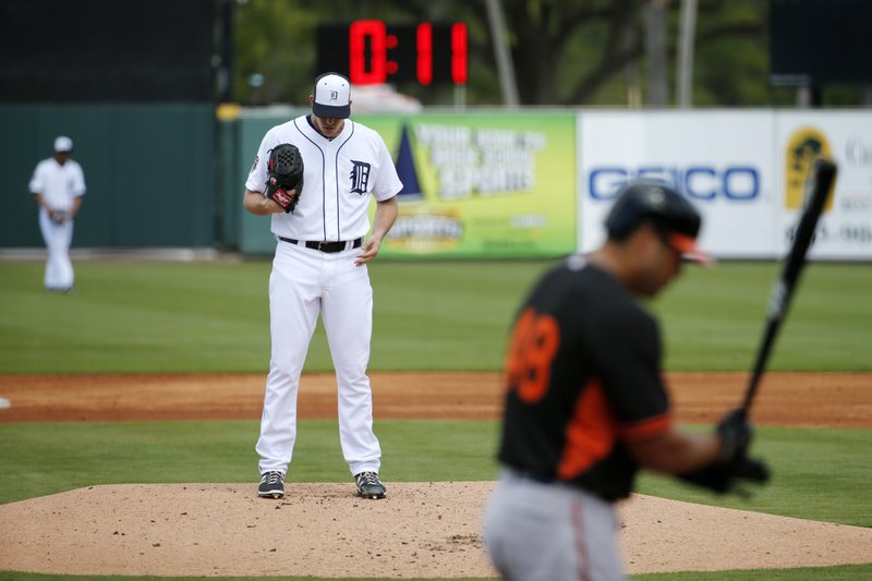 In this March 3,  2015, file photo, a clock counts down as Detroit Tigers pitcher Kyle Lobstein, left, prepares to deliver his first pitch of the second inning to Baltimore Orioles' Matt Tulasosopo during a spring training exhibition baseball game  in Lakeland, Fla. Pitchers will have to beat the clock at Triple-A and Double-A this season. In an effort to speed games, Minor League Baseball's governing body said Tuesday, March 24, 2015, a ball will be called in the count starting May 1 when a pitcher fails to start his windup or reach the set position within 20 seconds after having possession of the ball on the mound. 