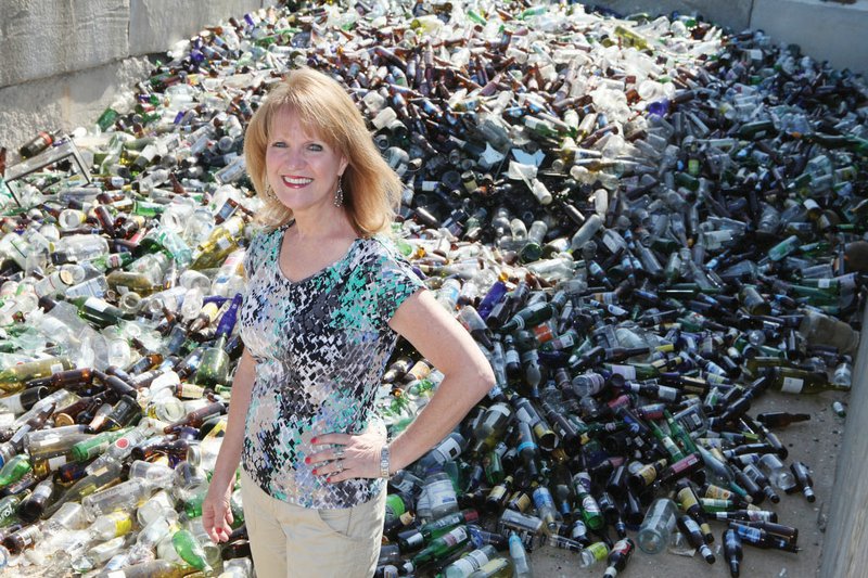 In this 2012 photo, Cheryl Harrington stands in front of 11,000 pounds of glass to be recycled. Harrington, 50, died March 12 after a 15-year battle with cancer. She had been director of sanitation since 2003. Jack Bell, 62, chief of staff for the city of Conway, was tapped earlier this month by Mayor Tab Townsell to serve as interim director. Bell will continue to represent the city on committees and fulfill some of his regular duties, Townsell said. Both men said it will be hard to replace Harrington, who expanded and improved the department through the years.