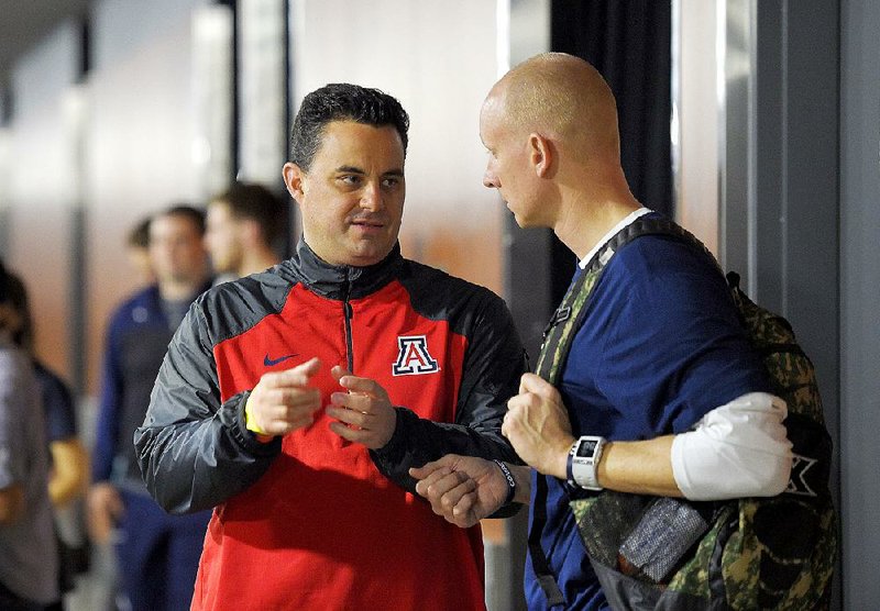 Arizona Coach Sean Miller (left) and Xavier Coach Chris Mack talk Wednesday at the Staples Center in Los Angeles. Mack was on Miller’s staff at Xavier before Miller left in 2009. Their teams face off in the NCAA Tournament tonight. 