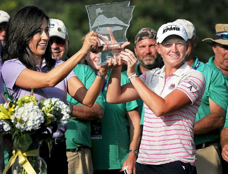 Stacy Lewis, right, holds up the trophy during a ceremony on the 18th green following the final round of the Walmart NW Arkansas Championship presented by P&G at Pinnacle Country Club in Rogers on Sunday June 29, 2014. 