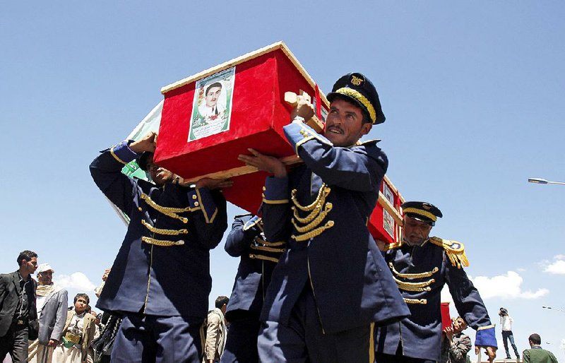 Members of a Yemeni honor guard carry the coffin of a victim of last week’s suicide bombings in Sanaa during a funeral procession Wednesday in Sanaa.