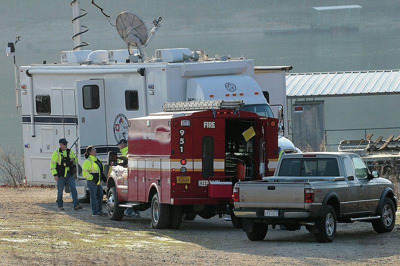 NWA Democrat-Gazette/FLIP PUTTHOFF Fire and rescue personnel stand by Wednesday morning at Beaver Lake in the Coppermine community east of Rogers. Officials were searching for a woman reported missing Tuesday evening.
