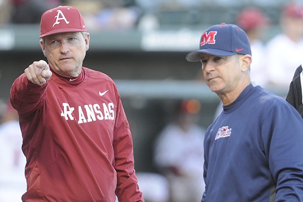 Arkansas coach Dave Van Horn, left, and Ole Miss coach Mike Bianco talk prior to a game Thursday, March 26, 2015, at Baum Stadium in Fayetteville. 