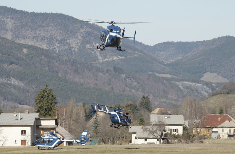 Rescue helicopters land and take off, top, in Seyne-les-Alpes, France, Thursday March 26, 2015. The Germanwings Airbus A320, on a flight from Barcelona, Spain, to Duesseldorf, Germany,inexplicably began to descend from cruising altitude after losing radio contact with ground control and slammed into a remote mountainside in the French Alps on Tuesday, killing all 150 people on board. 