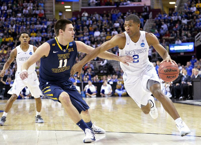 Kentucky guard Aaron Harrison (2) looks to drive past West Virginia defender Nathan Adrian during a Midwest Region semifinal Thursday in Cleveland. The top-seeded Wildcats easily moved to 37-0 and into the Elite Eight with a 78-39 victory. 