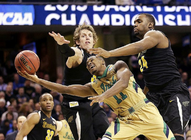 Notre Dame’s Demetrius Jackson (11) shoots past Wichita State’s Evan Wessel and Shaquille Morris (24) during the second half of Thursday’s game in the NCAA Midwest Regional semifinals in Cleveland. Jackson finished with 20 points to help lead the Irish into the Elite Eight.