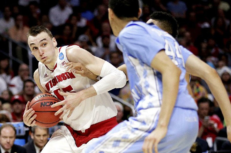 Wisconsin forward Sam Dekker drives past North Carolina defenders during the second half of Thursday’s West Region semifinals in Los Angeles. Dekker scored 23 points to lead the Badgers. 