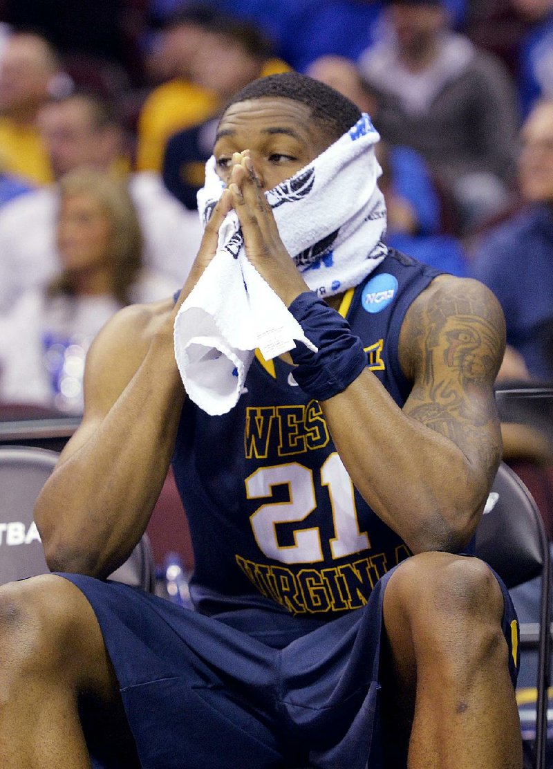 West Virginia’s BillyDee Williams watches from the bench during the second half of Thursday’s game against Kentucky in the NCAA Midwest Region semifinals in Cleveland. Undefeated Kentucky won by 39 points. 