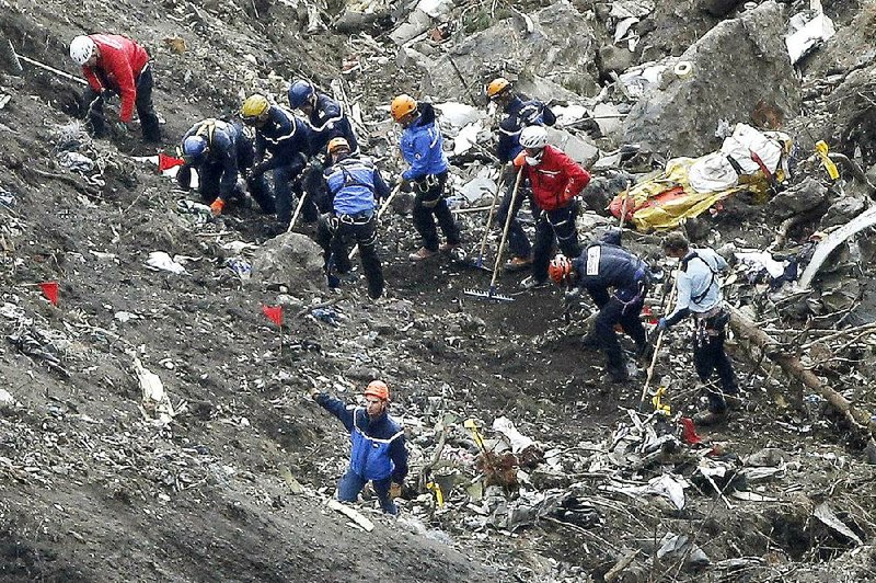 Rescue workers search the debris of the Germanwings jetliner at the crash site near Seyne-les-Alpes, France. 